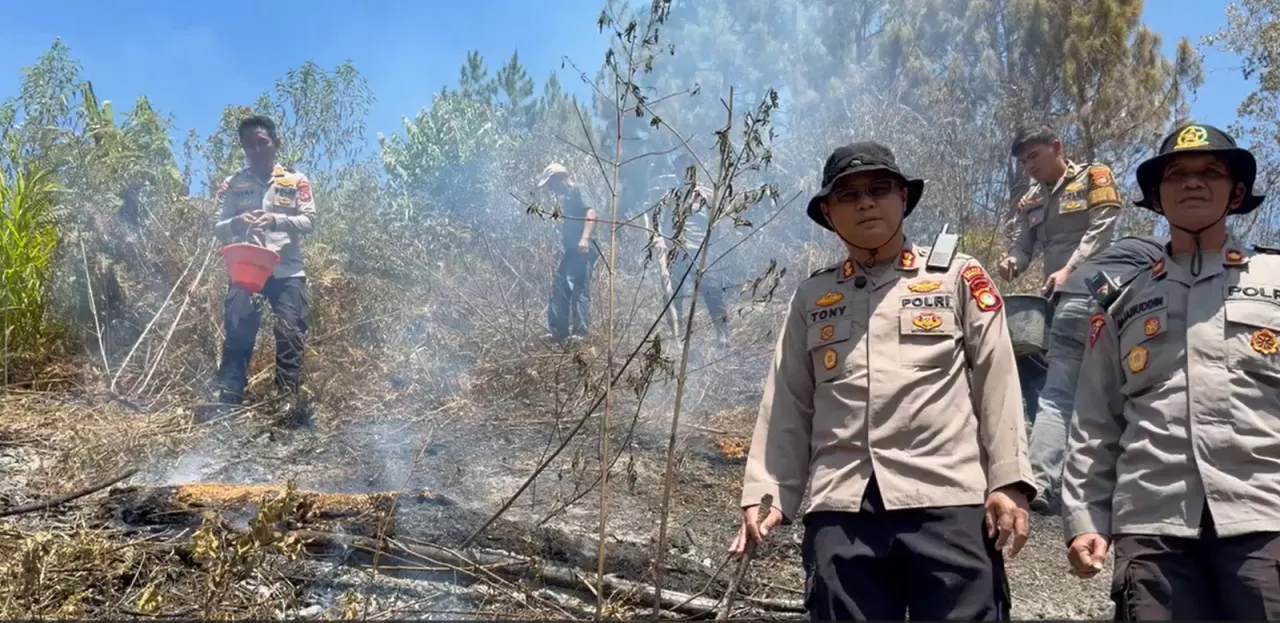 Polisi memadamkan api yang membakar hutan