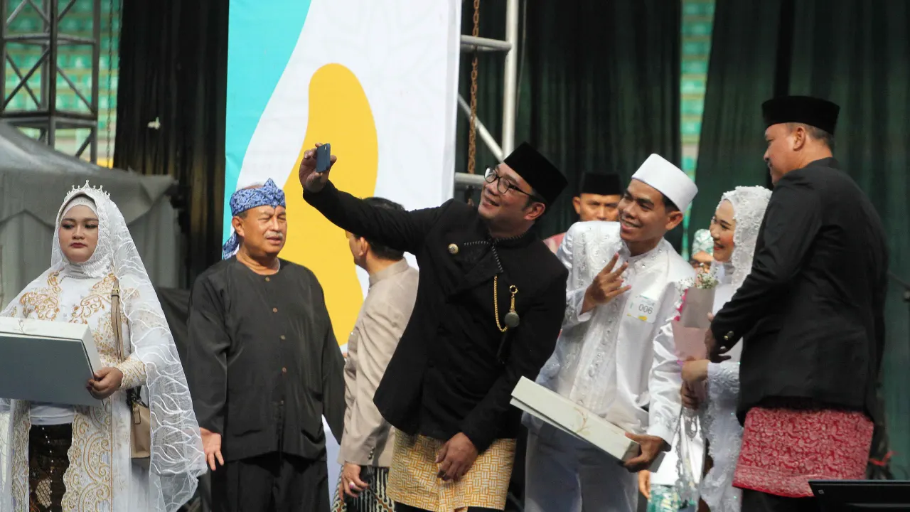 Gubernur Jawa Barat Ridwan Kamil berfoto bersama peserta nikah massal juara.